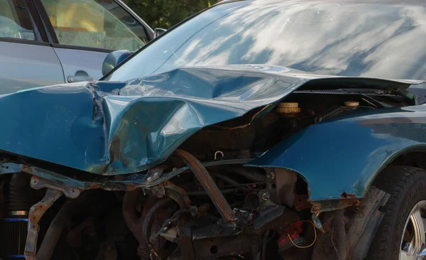 Capuz deformado e mal enrugado de um carro azul escuro. — Fotografia de Stock