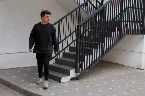 El tipo está subiendo las escaleras en la entrada de la ciudad. — Foto de Stock