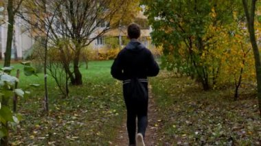 Bir genç şehir parkında yürüyor..