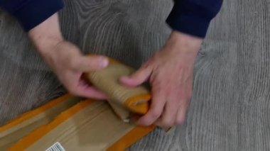 Erkek eller kullanılmış bir karton kutuyu katlıyor..