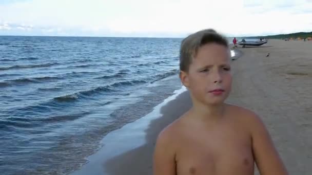 Pojke promenader på sandstranden till havs. — Stockvideo