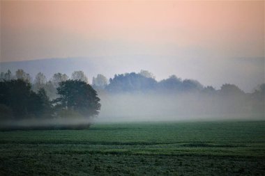 Güneşin doğuşu sisli manzara