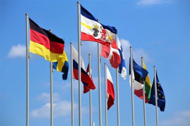 Mavi gökyüzünün arka planında farklı ülkelerin bayrakları