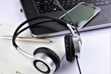 Kulaklık ve klavyeli bir ofis masasının konsept görüntüsü