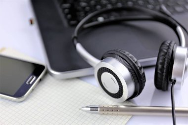 Kulaklık ve klavyeli bir ofis masasının konsept görüntüsü