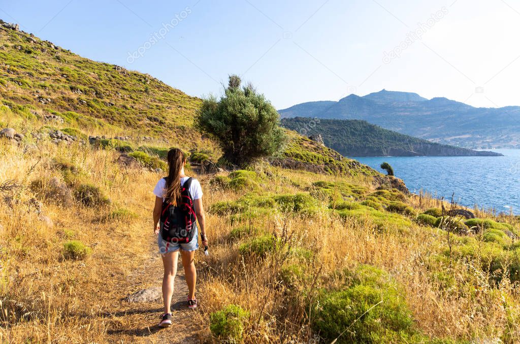 Woman walking on scenic seashore - Lesbos, Greece