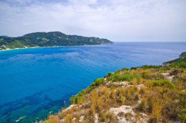 Lagün ve yüksek kayalıklarla yakınındaki Agios Georgios, Corfu, Yunanistan
