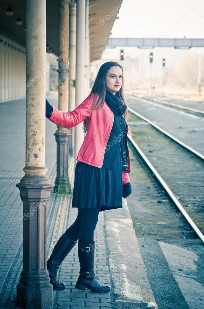 Woman waiting for train on old rail station