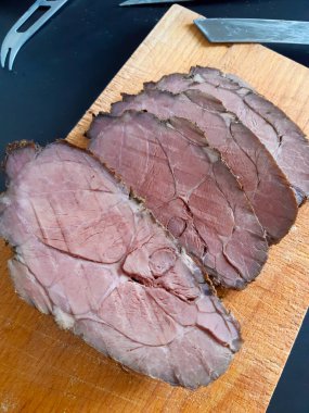 Biftek dilimlerinin tadını çıkarın, akşam yemeği ya da gurme öğle yemeği için mükemmel. Taze, lezzetli ve rafine bir yemek için ahşap bir tahtanın üzerinde servis yapmaya hazır..