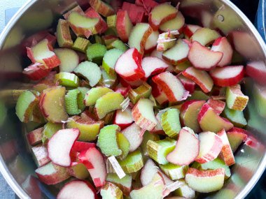 Taze doğranmış ravent, lezzetli bir bahar tatlısına dönüşmeye hazır. Canlı renkler ve sağlıklı beslenmek için sağlıklı malzemeler..