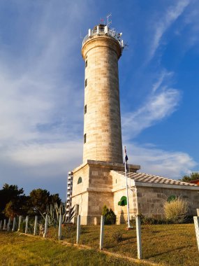 Çarpıcı deniz feneri mavi gökyüzüne karşı dimdik ayakta duruyor. Bu ikonik deniz simgesi ile macera ve sükunet duygusu aşılayın..