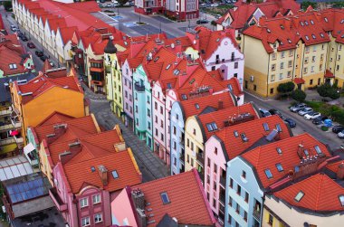 Renkli binaları ve kırmızı çatıları olan hareketli Avrupa kasabası seyahat ve yaşam tarzı içeriği için mükemmel büyüleyici, resim gibi bir manzara yaratıyor. Gezgin şehvetine ilham verir.