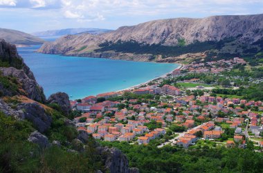 Turkuaz deniz kıyısında sakin bir kıyı kasabası keşfedin. Seyahat, turizm ve tatil temaları için mükemmel. Cennet gibi Akdeniz yaşamının özünü yakala..