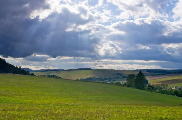 Зеленый луг под яркими облаками — стоковое фото