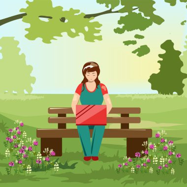 Parkta dizüstü bilgisayarda çalışan bir kadın.