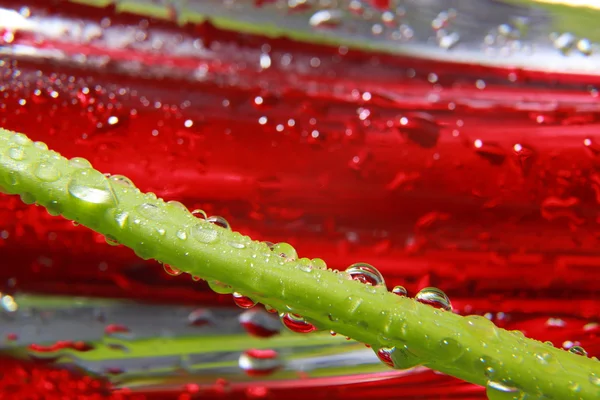 Shiny water drops sprayed on textured red surface. — Stock Photo, Image