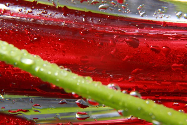 Glanzende waterdruppels gespoten op geweven rode oppervlak. — Stockfoto