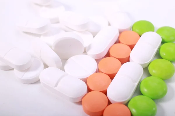 Stak af forskellige piller isoleret på hvid baggrund - Stock-foto