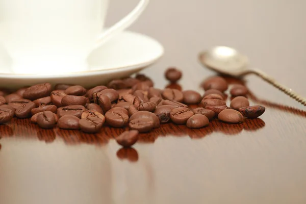 Taza de café y platillo en una mesa de madera. Fondo oscuro. —  Fotos de Stock
