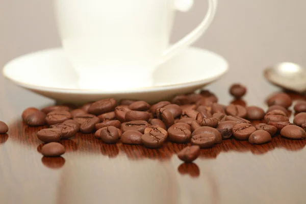 ถ้วยกาแฟและจานบนโต๊ะไม้ พื้นหลังมืด . — ภาพถ่ายสต็อก