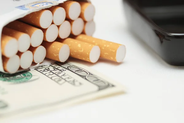 香烟和钱。昂贵的习惯。白色背景-水平照片. — 图库照片