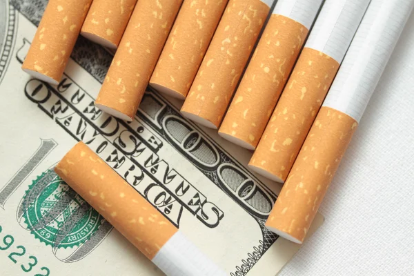 Cigarettes and money. expensive habit. white background - horizontal photo. — Stock Photo, Image