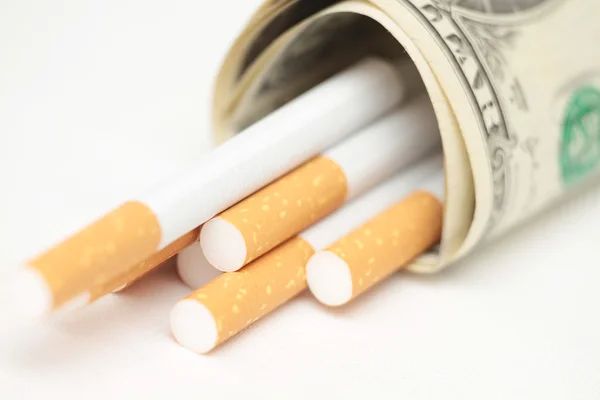 Τσιγάρα και χρήματα. δαπανηρή συνήθεια. λευκό φόντο - οριζόντια φωτογραφία. — Φωτογραφία Αρχείου
