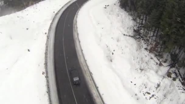 田舎のカルパチア山脈の雪で覆われた道路の空中ショット — ストック動画