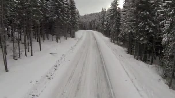 Aerial shot of snow-covered road in the countryside Carpathian Mountains — Stock Video