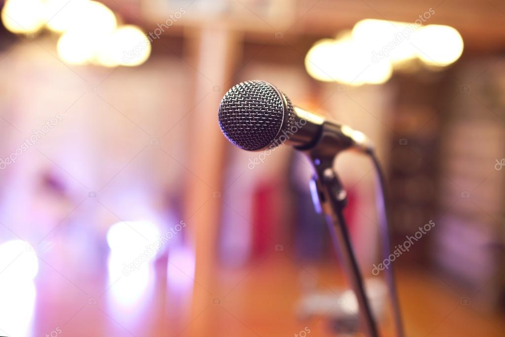 Close-up of a microphone in a concert hall on the background of blurred lights