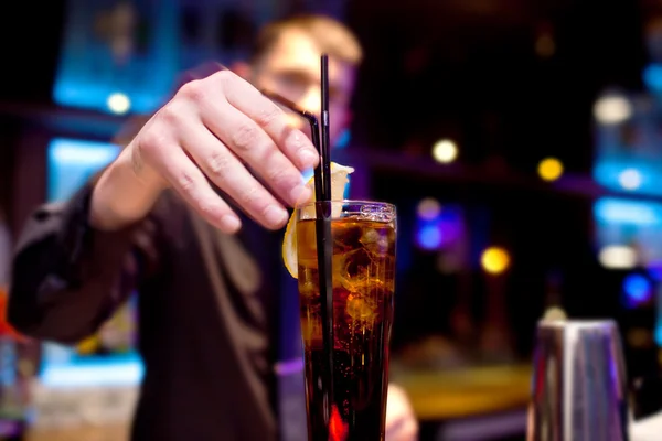 De barman siert plakje citroen glas van koolzuurhoudende drank — Stockfoto