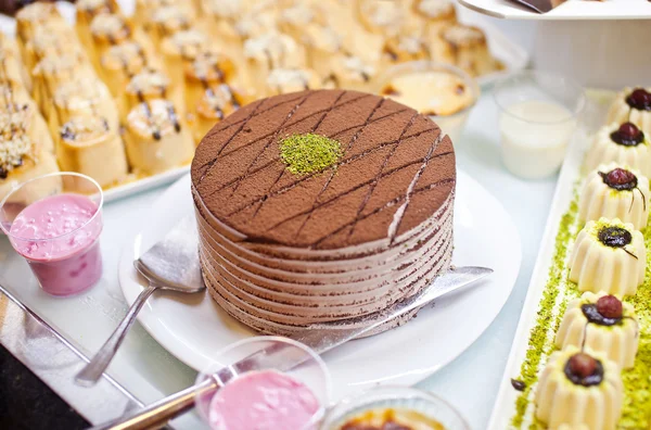 Gâteau au chocolat aux pistaches et soufflé sur table buffet — Photo