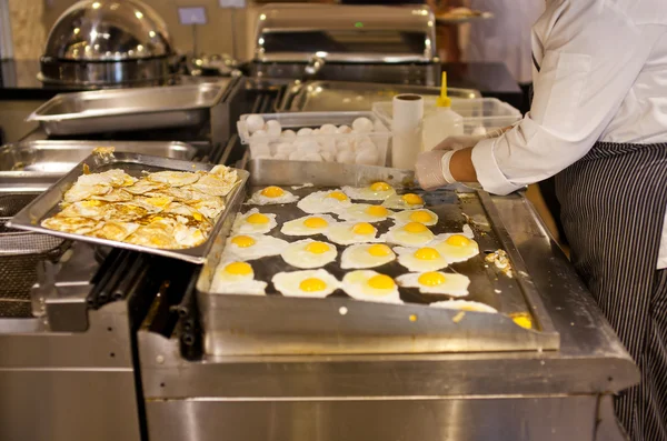O cozinheiro está cozinhando uma omelete para um café da manhã — Fotografia de Stock