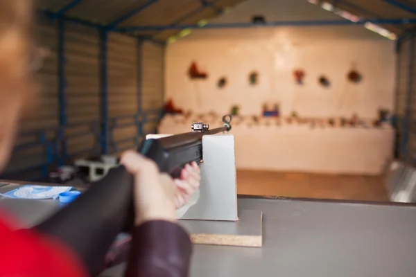 Mujer dispara un arma en un campo de tiro —  Fotos de Stock