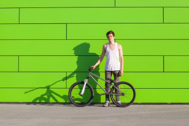 Kal yeşil duvar arka plan gümüş bisikleti ile çocuk
