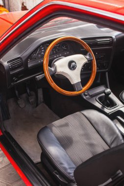 KYIV, UKRAINE - 24 Mayıs 2020: Ahşap direksiyonlu ve açık kapılı kırmızı retro bir arabanın içi.