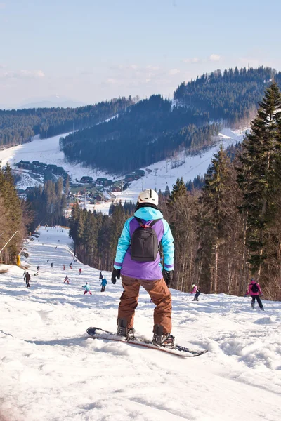 Esquiadores e snowboarder desce da montanha — Fotografia de Stock