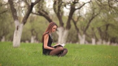 Yeşil çim üzerine bir kitap okuma kız