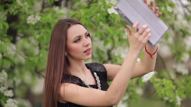 Mujer joven haciendo selfie en el jardín — Vídeos de Stock