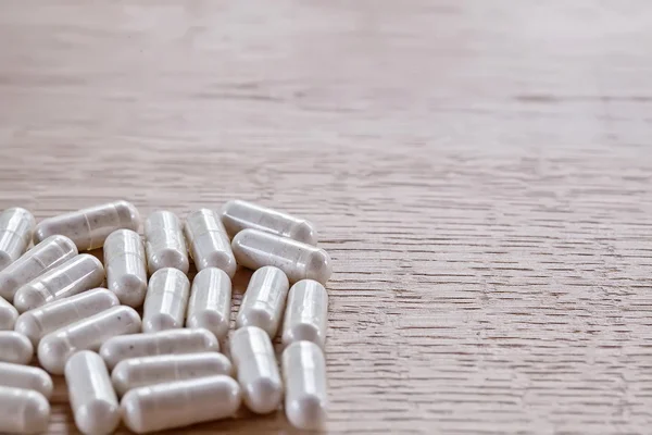 Capsules on a wooden surface — Stock Photo, Image