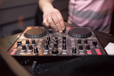 DJ gece kulübünde konsolda müzik karıştırıyor.