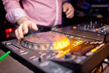 DJ gece kulübünde konsolda müzik karıştırıyor.
