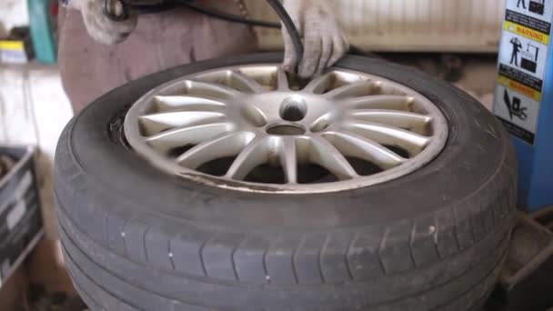 Monteur in de dienst reparatie auto wiel — Stockvideo