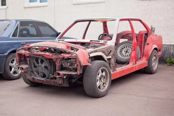 Zijaanzicht van rode oude roestige auto — Stockfoto