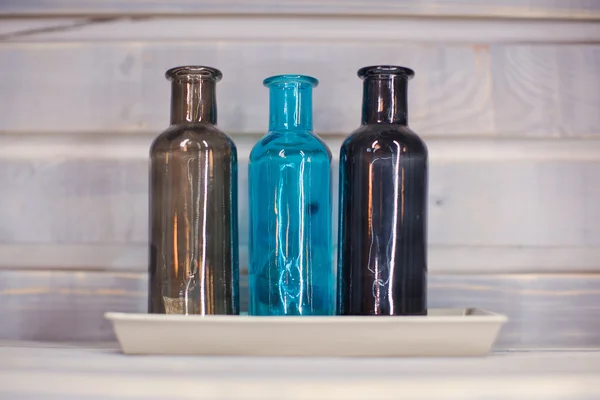 Trois bouteilles décoratives colorées un fond bleu — Photo