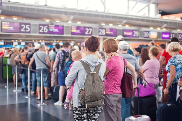 Kobieta z dzieckiem czeka na rejestrację samolot — Zdjęcie stockowe