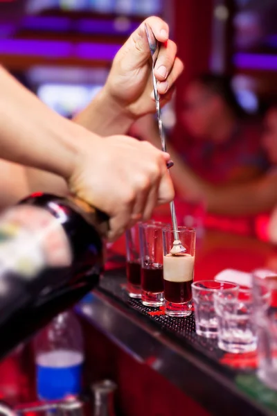 De barman handen in interieur bar zijn gegoten drank — Stockfoto