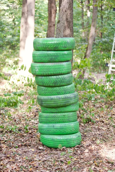 Stack of old green tires in the forest — Stock Photo, Image