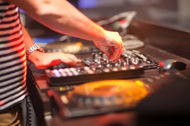 DJ gece kulübünde konsolda müzik karıştırıyor.