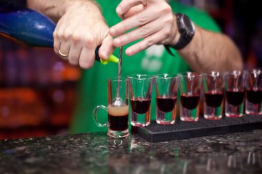 Barmen bir kokteyl atış yapar